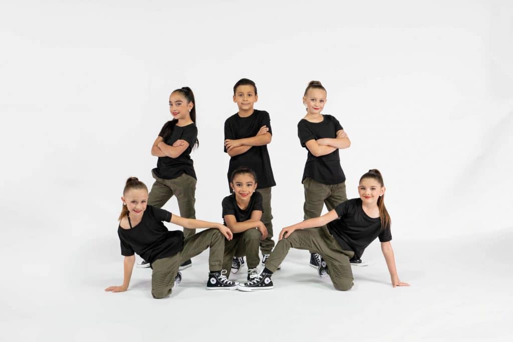 A group of young dancers posing in streetwear.