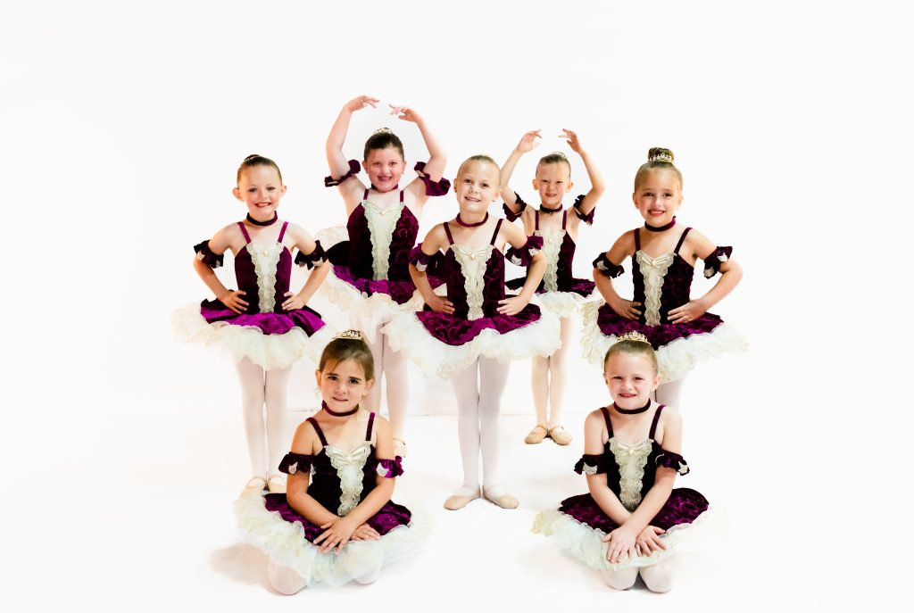 Young students posing in ballet garb.